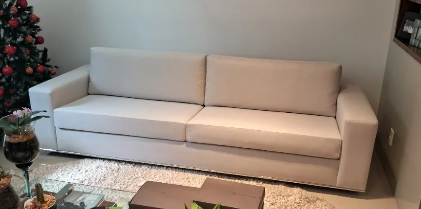 Sofá claro de dois lugares em sala de estar