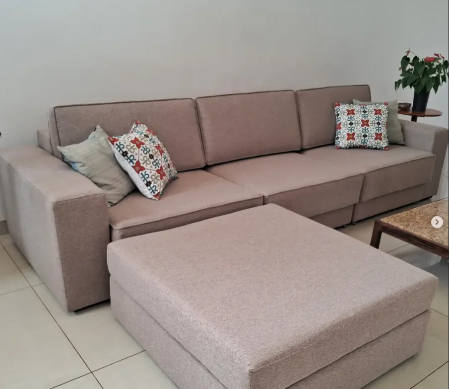 Sofá rosado com chaise e almofadas decorativas
