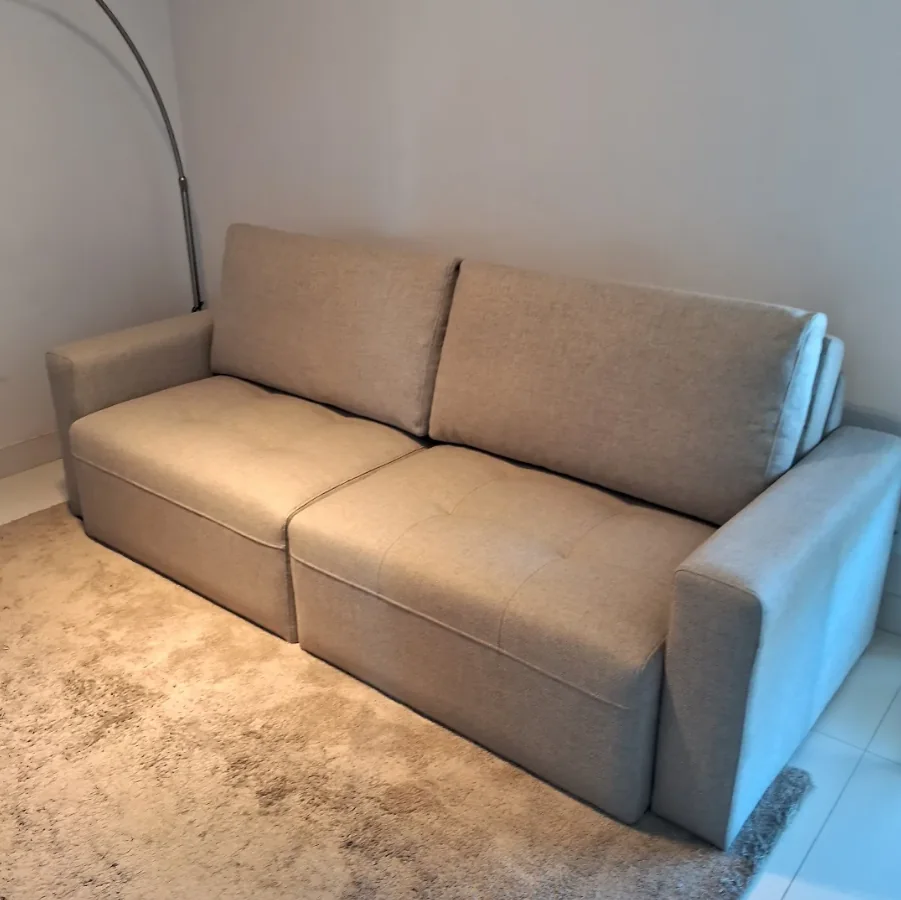 Sofá bege de dois lugares em ambiente residencial